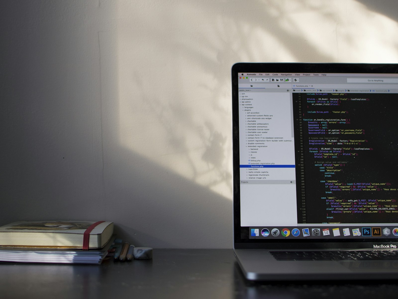 A laptop showing code on a desk in warm daylight.